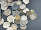 a pile of old coins on a black surface