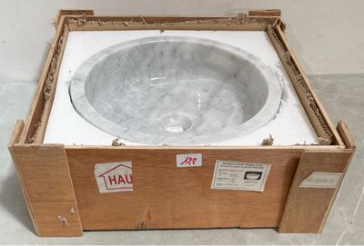 une caisse posée par terre, avec un lavabo à l'intérieur