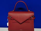 un sac à main rouge posé sur une table blanche
