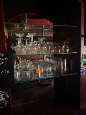 a bar with a lot of wine glasses on the shelves