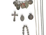 an assortment of silver jewelry including a cross, a necklace, and other items
