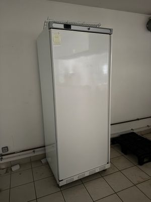 un réfrigérateur blanc dans le coin d'une pièce