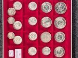 une boîte de pièces d'argent posée sur un sol recouvert de moquette
