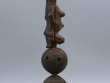 a wooden sculpture of a person on top of three balls
