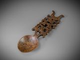 a close up of a wooden spoon with a carved handle