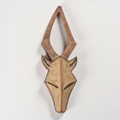 a close up of a wooden animal head mounted on a wall
