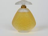 yellow glass perfume bottle with a white lid on a white surface