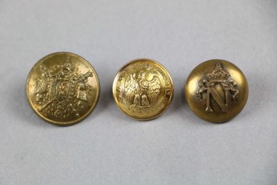trois boutons en or sur lesquels sont représentés un homme et une femme