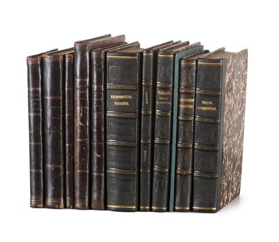 plusieurs vieux livres sont alignés sur une surface blanche