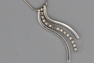 Collier en or orné d’un pendentif composé de trois baguettes…
