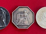 trois pièces d'argent posées sur un fond rouge