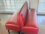 a red leather bench in the middle of a room