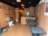 a room with a table, chairs, and a refrigerator