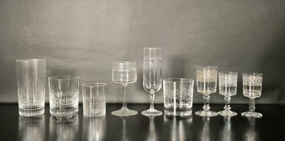 un grand nombre de verres à vin vides posés sur une table