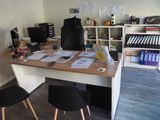 a desk with two chairs and a computer on it