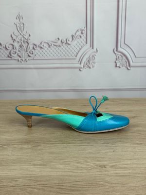 blue and green shoes on a wooden table with a wall in the background