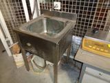 a sink in the middle of a room with a wire fence in the background