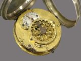 a gold pocket watch that is open on a gray background