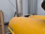 a man standing next to a yellow tank in a building