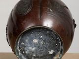 a brown vase sitting on top of a wooden table