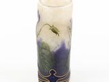 a vase with purple flowers on it on a white surface