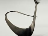 silver spoon with a white stone on it sitting on top of a white surface