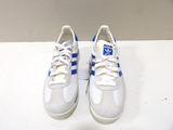 a pair of white and blue sneakers sitting on a table