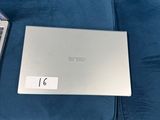 a lap top on a blue couch next to a remote control