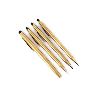 trois stylos de couleur dorée posés les uns à côté des autres sur une surface blanche