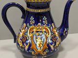 a blue and gold teapot on a white table