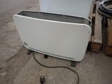 a white heater sitting on the ground next to a wooden pallet