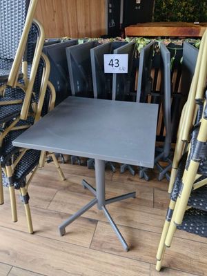 plusieurs chaises et une table dans une pièce où figure le numéro 43 sur la table