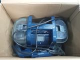 a box with a blue vacuum cleaner in it