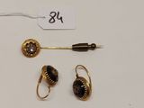 un gros plan sur une paire de boucles d'oreilles et un stylo posés sur une table