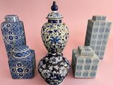 several blue and white vases sitting on top of a pink surface