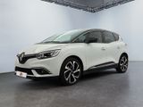 Une voiture blanche est garée dans une grande pièce.
