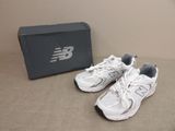 une paire de chaussures de course New Balance devant une boîte