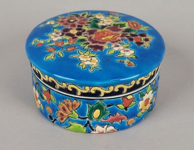 une petite boîte bleue ornée d'un motif floral