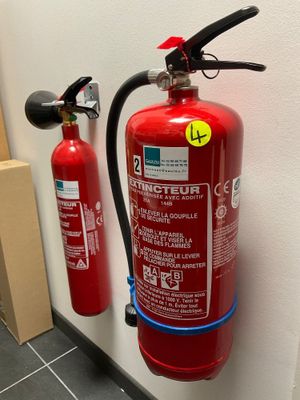 un extincteur fixé au mur d'une pièce