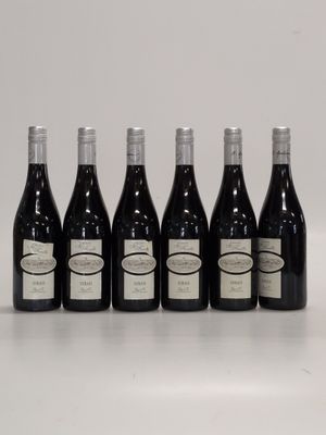 six bottles of wine are lined up on a white surface