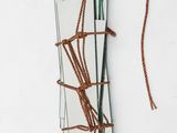 a mirror hanging on the wall with a rope attached to it
