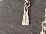 a silver chain with a silver charm hanging from it