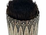 a black brush in a silver cup on a white background