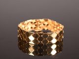 a close up of a gold bracelet on a black surface