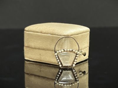 une petite boîte sur laquelle est posé un collier, posée sur une table