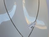 chaîne en argent avec un pendentif en forme de cœur rouge sur un mannequin blanc