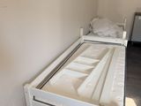 a white bed with a wooden frame in the corner of a room