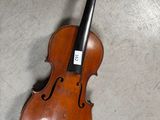 un vieux violon posé par terre dans une pièce
