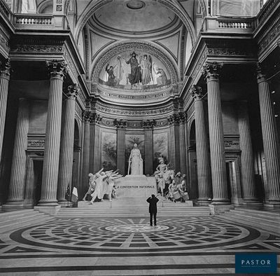 photographie en noir et blanc d'une personne debout dans un grand bâtiment