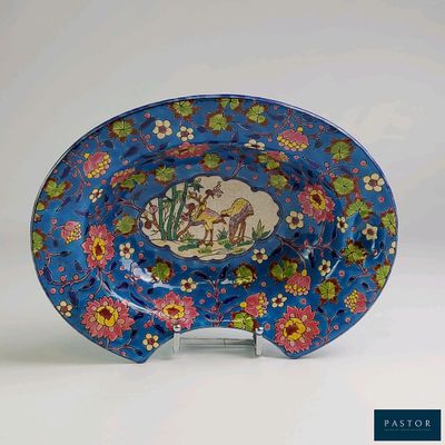 une assiette bleue sur laquelle sont représentés un cheval et des fleurs